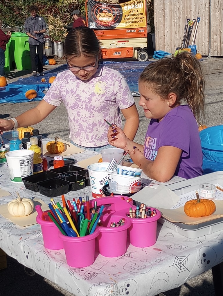 two children painting pumpkins